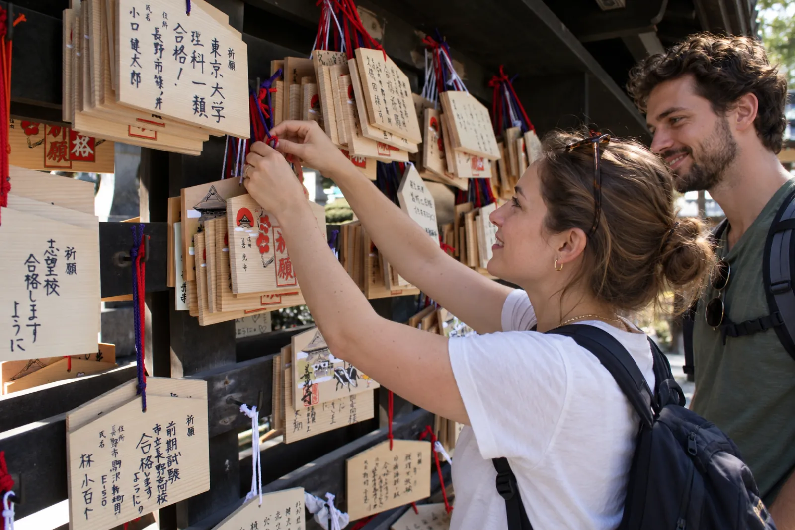 Travellers hanging wooden ema prayer plaques at Zenko-ji